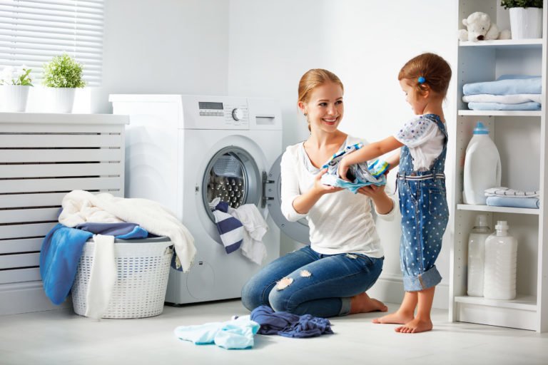 Woman loading newly repaired washing machine